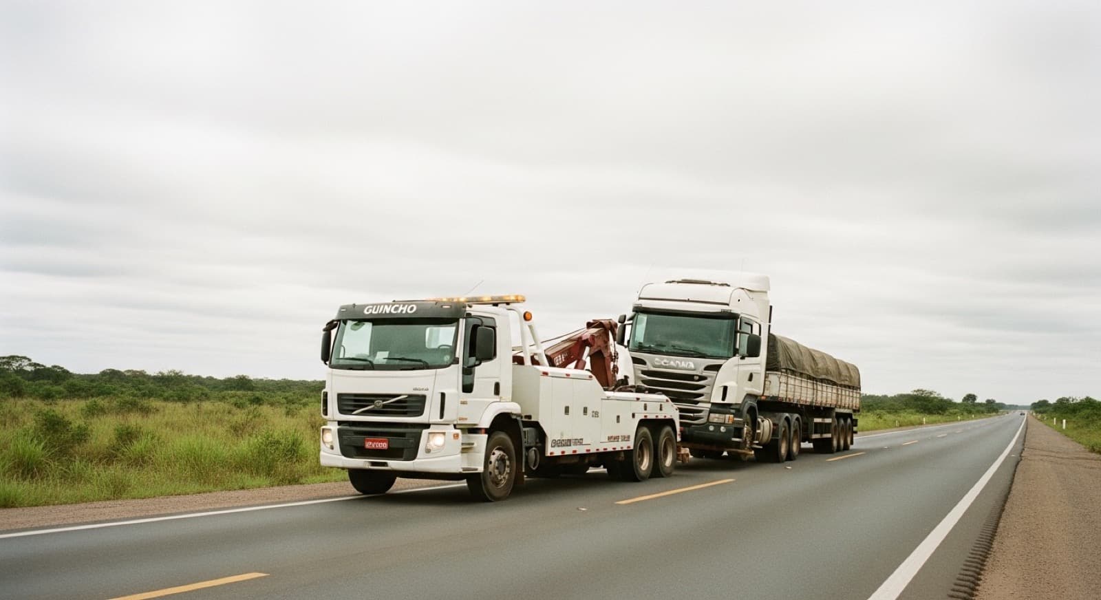 Guincho de reboque pesado socorrendo caminhão Scania em rodovia federal brasileira